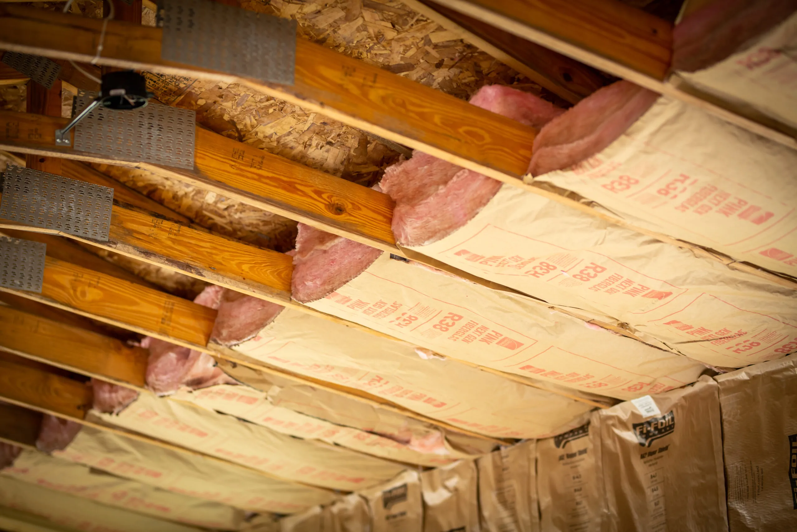 Fiberglass batt insulation installed between joists