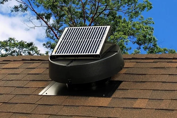 Solar powered attic vent with integrated solar panel on asphalt shingle roof